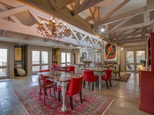 a dining room with tables and red chairs at La Serenita @ Migdash in Hartbeespoort