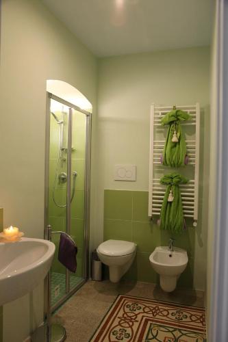 bagno verde con servizi igienici e doccia di Locus Amoenus Luxury Rooms a Corato