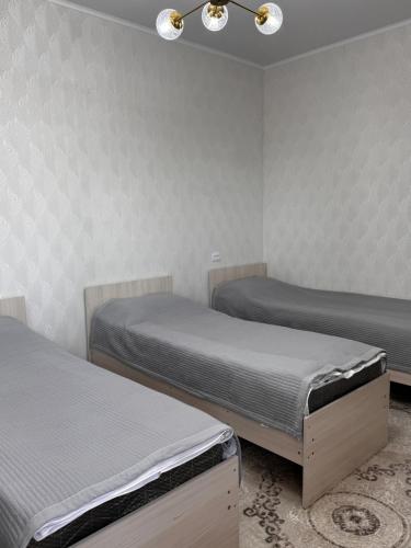 a room with two beds and a ceiling at Cholpon Guest House & Hostel in Toktogul