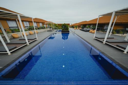 a swimming pool with blue water in a building at Monkeys Canopy Resort in Kajang