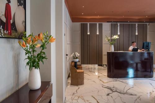 a man sitting at a podium in a lobby at Palazzo Buenos Aires in Milan