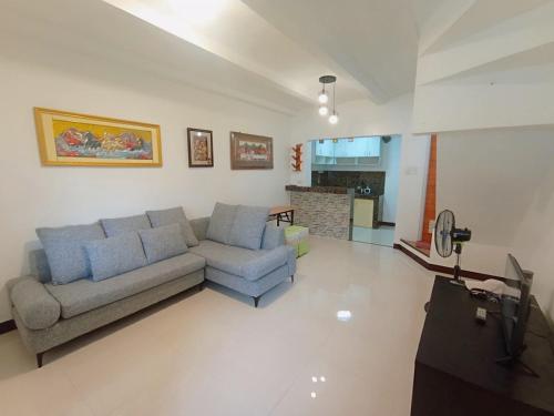 een woonkamer met een bank en een tv bij JeSa's Serenity Sanctuary in Dasmariñas