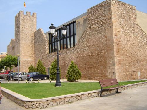 a building with a street light next to a bench at Cal Barceló in Vandellós