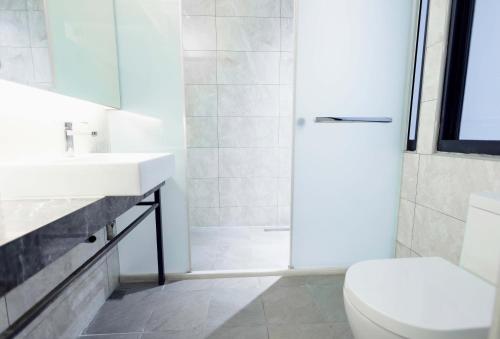a bathroom with a shower and a toilet and a sink at Wondertime Taipei Station - Chongqing Inn in Taipei
