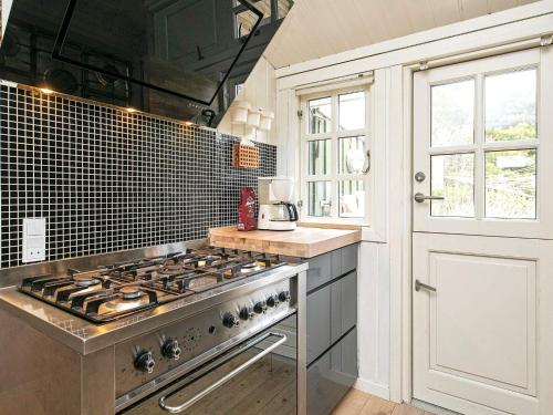 a kitchen with a stove top oven next to a window at 6 person holiday home in Jerup in Jerup