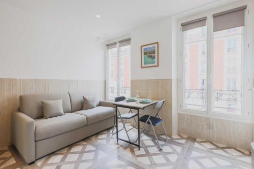 een woonkamer met een bank en een tafel bij Studio cosy - 2P - Bercy in Parijs