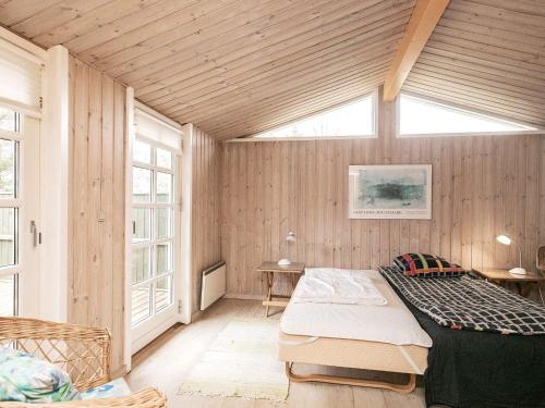 a bedroom with a bed in a room with wooden walls at 6 person holiday home in Jerup in Jerup