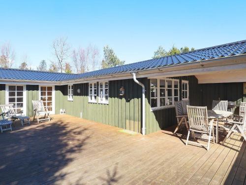 a deck with chairs and a table on a house at 6 person holiday home in Jerup in Jerup