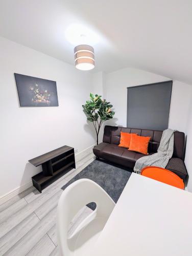 a living room with a couch and a table at Chic En-suite Room with Office Garden and Parking New Renovation in Wainscot
