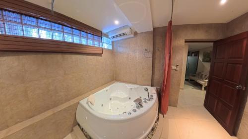 a bathroom with a tub and a sink at The Nai Harn Collective in Rawai Beach