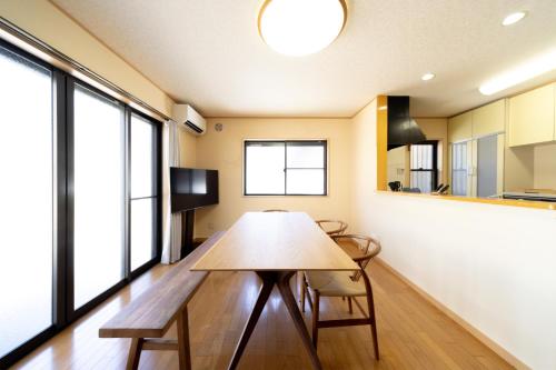 a dining room with a table and some windows at rinne 熱海 Retreat in Atami