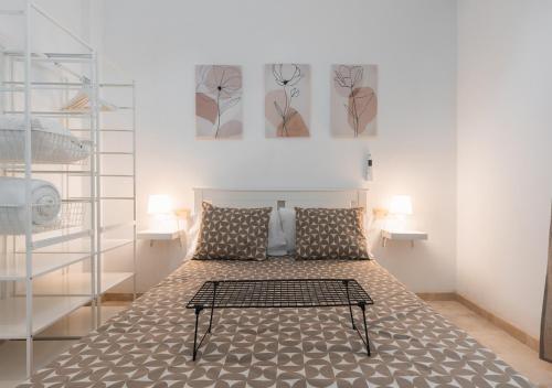 ein Schlafzimmer mit einem Bett mit zwei Gemälden an der Wand in der Unterkunft Home4u Castañeda 1º in Granada