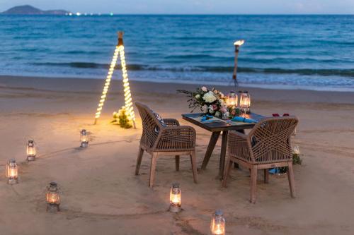 a table and chairs on the beach with lights at Mia Resort Nha Trang in Nha Trang