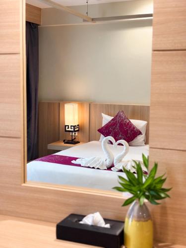 a bedroom with a bed with two swans on it at Apasari Krabi - SHA Extra Plus in Ao Nang Beach