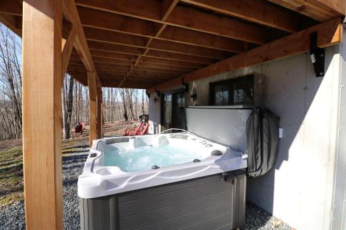 a jacuzzi tub sitting under a roof at Luxury Spa & Game Room - Le Havre du Voyageur in La Minerve