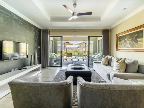 a living room with two chairs and a couch at Shepherds Tree Game Reserve in Pilanesberg