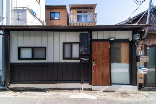 a building with a wooden door and a window at 夏様賀陽御所 Cozy Kyoto Machiya, 4 min walk Shijo Omiya,Perfect for 3 Guests in Kyoto