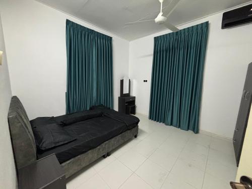 una camera da letto con un letto nero e tende verdi di Homestay Kita Kg Bechah Keranji a Ketereh