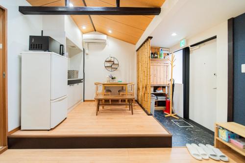 a small kitchen with a table and a refrigerator at 夏様賀陽御所 Cozy Kyoto Machiya, 4 min walk Shijo Omiya,Perfect for 3 Guests in Kyoto