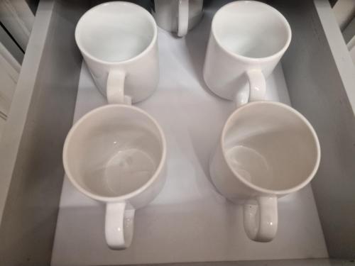 a group of four white urinals in a room at Lakeview terrace studio in Namulanda