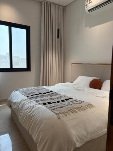 ダンマームにあるLuxury 1BR Suite Walk to Café&Supermarketの窓のある大きな白いベッドのある寝室