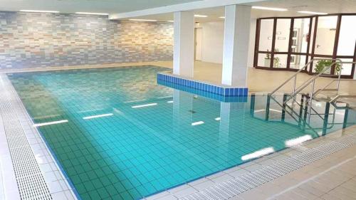 a swimming pool with turquoise tiles on the floor at PEMATRA FeWo Nordlicht in Travemünde