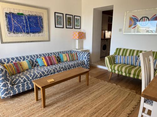 a living room with two couches and a coffee table at Sea views at Quay Rocks in Seaview