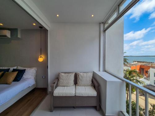 a bedroom with a bed and a balcony with a view at Moderna suite con balcón a pasos de la playa in Cartagena de Indias