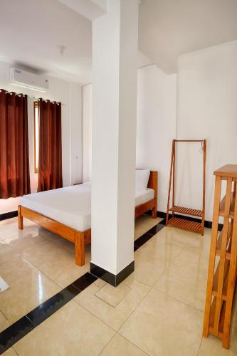 a bedroom with a bed and a mirror in it at NOMAD Tropical Hotel Canggu in Dalung