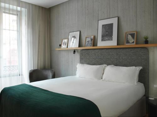 a bedroom with a large white bed and a window at Hôtel National Des Arts et Métiers in Paris