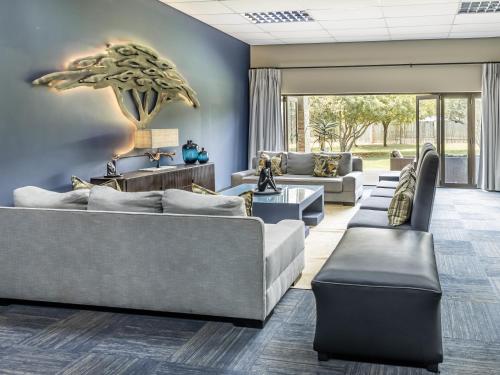 a large living room with couches and tables at Shepherds Tree Game Reserve in Pilanesberg