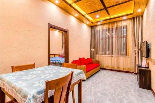a living room with a table and a red couch at Snow house in Sanrenban