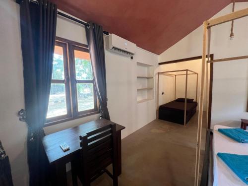 a bedroom with a desk and a window and a mirror at Sand Dune Beach Resort & Surf Camp in Arugam Bay