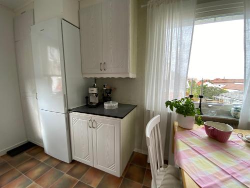 a kitchen with a table and a white refrigerator at Kungshamn - Fisketången in Kungshamn