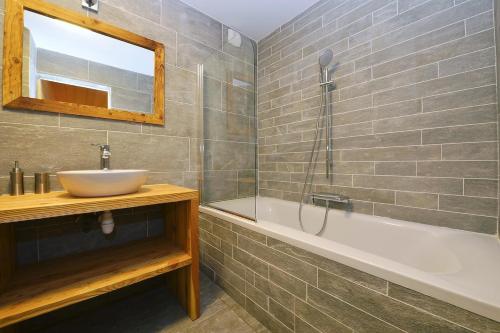 a bathroom with a sink and a bath tub at TETRAS Chalet de prestige, 12 personnes , Pieds des pistes in Vars