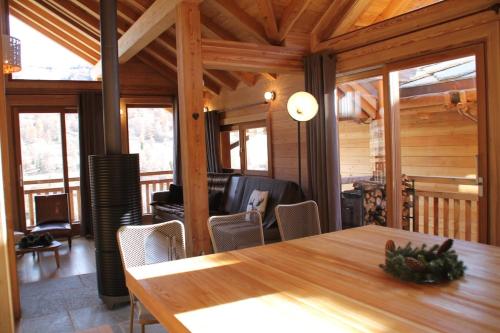 a dining room with a wooden table and chairs at TETRAS Chalet de prestige, 12 personnes , Pieds des pistes in Vars