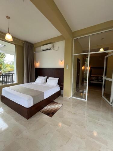 a bedroom with a large bed and a balcony at Ella Family House in Ella