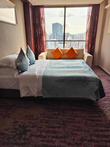 a hotel room with a bed and a large window at Guangdong Hotel (Zhuhai) in Zhuhai