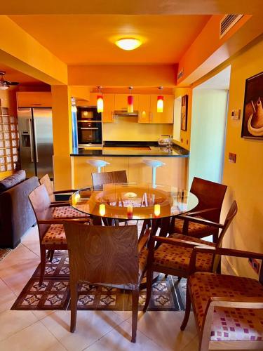 a dining room with a table and chairs and a kitchen at Dar NFis Suites et chambres de luxe dans un havre de paix vue paradisiaque au bord du lac in Lalla Takerkoust