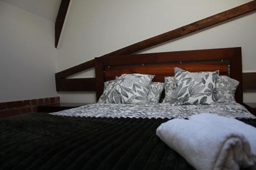 a bedroom with a bed with a wooden headboard and pillows at Brickworks Heritage Loft in Melbourne