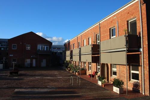 an empty parking lot next to a brick building at Brickworks Heritage Loft in Melbourne