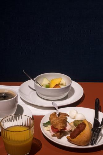 a table with two plates of food and a bowl of fruit at Palazzo Buenos Aires in Milan