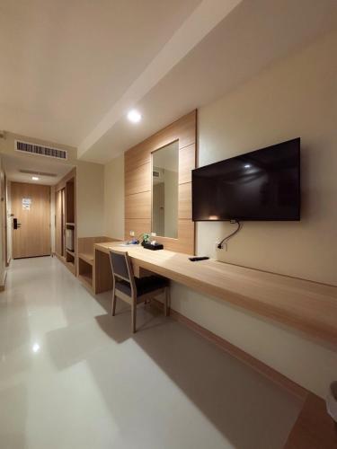 a room with a desk with a television on the wall at Apasari Krabi - SHA Extra Plus in Ao Nang Beach