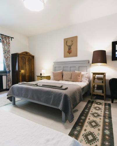 a bedroom with a large bed and a rug at Ceruzás ház in Nagyrákos