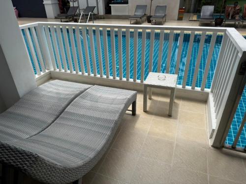 a pool with a bench and a table next to it at Apasari Krabi - SHA Extra Plus in Ao Nang Beach