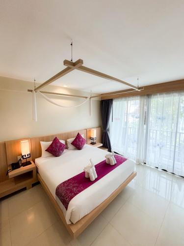 a bedroom with a large bed with two stuffed animals on it at Apasari Krabi - SHA Extra Plus in Ao Nang Beach