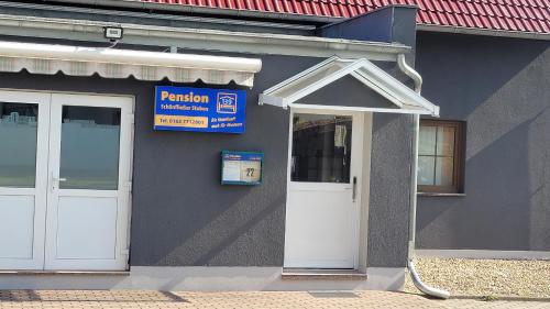 a building with a white door and a sign on it at Zimmervermietung Schönfließer Stuben auch für Monteure in Eisenhüttenstadt