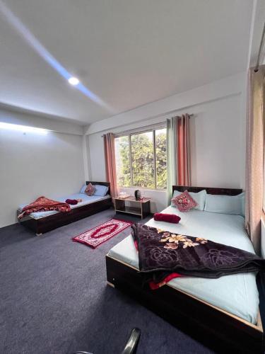ein Schlafzimmer mit zwei Betten und einem Fenster in der Unterkunft Nimbus Soulstay in Kalimpong