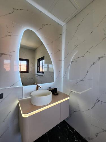 a white bathroom with a sink and a mirror at White Swan Mansion in Ketewel