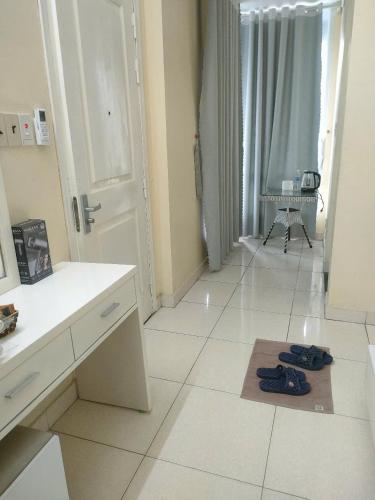 a white kitchen with a door and shoes on the floor at Nhật Minh Motel Hải Phòng in Hai Phong